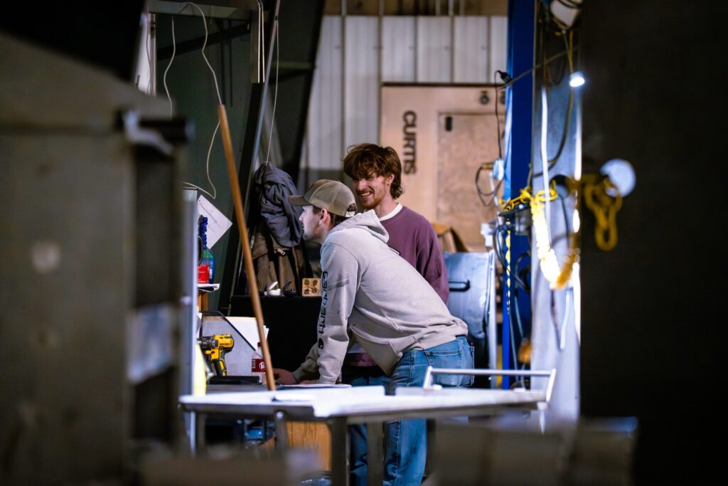 Two DC Equipment team members collaborating on a project in the fabrication shop